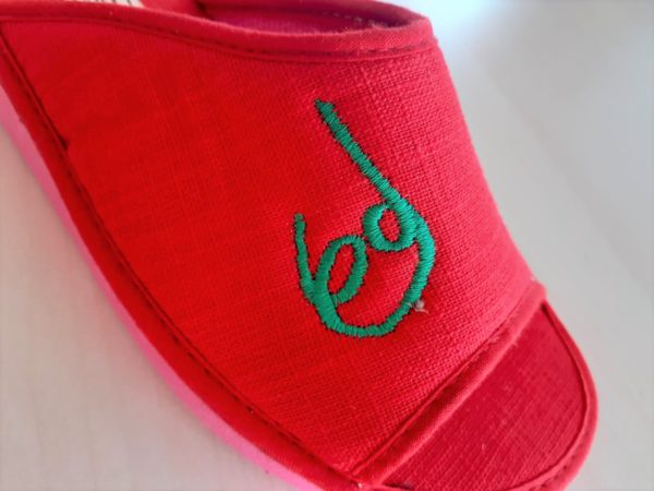 Zapatillas de andar por casa, con la puntera abierta, de color rojo con el logotipo de la Patum bordado en verde. Cómpralas en la Tienda de Patum de El Formiguer, el Centro Comercial Online del Berguedà.