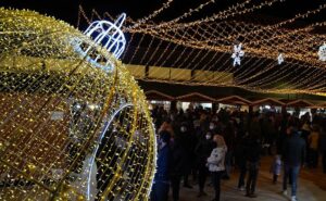 Imagen del Market Villa de Navidad de Gironella 2021, con una gran bola de Navidad de luz en primer plano y mucha gente de fondo asistiendo a las actividades.