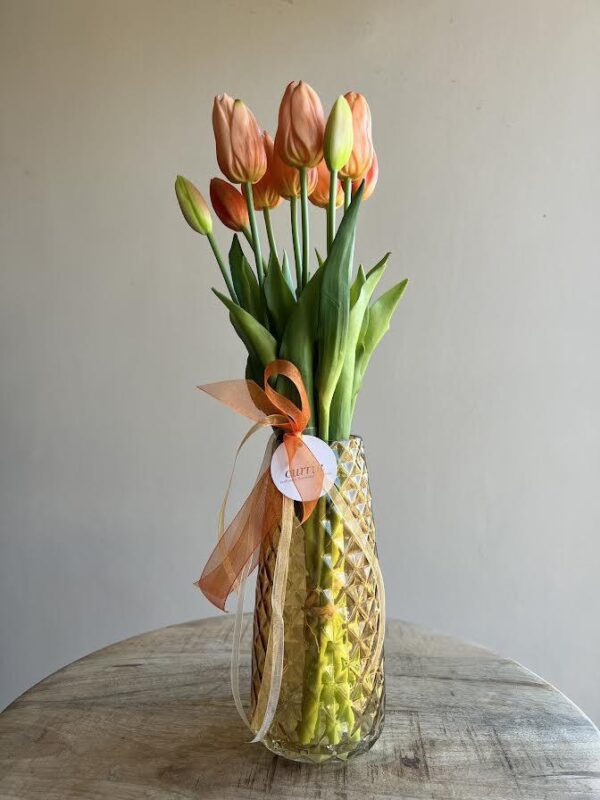 Precioso ramo de tulipanes naranjas artificiales de gran calidad, una imitación excelente! Incluye un jarrón a juego de color amarillo hecho de vidrio con textura de rombos. ¡Ten tulipanes del Berguedà todo el año en tu casa!