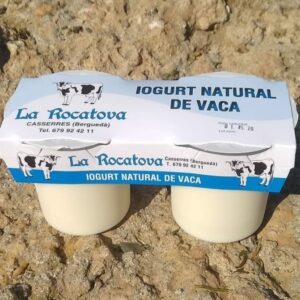 Dos yogures naturales de leche de vaca con un blister de cartón que los une, con tonos azules, donde llama Yogur natural de vaca y la marca La Rocatova, productores de esta especialidad láctica.