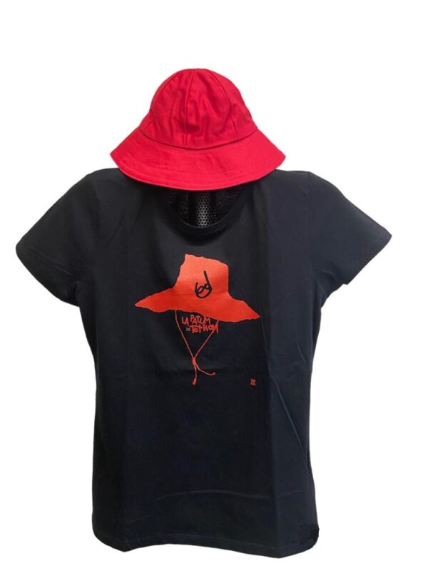 Samarreta oficial de la Patum 2023, en tallatge de dona, en un maniquí a La Patumaire, amb un barret vermell de Patum a sobre. La samarreta és negra amb el dibuix vermell d'un barret de Patum. Pots comprar-la online des d'El Formiguer!